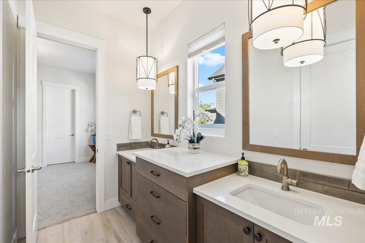 Bathroom with two vanities and wood finished floors