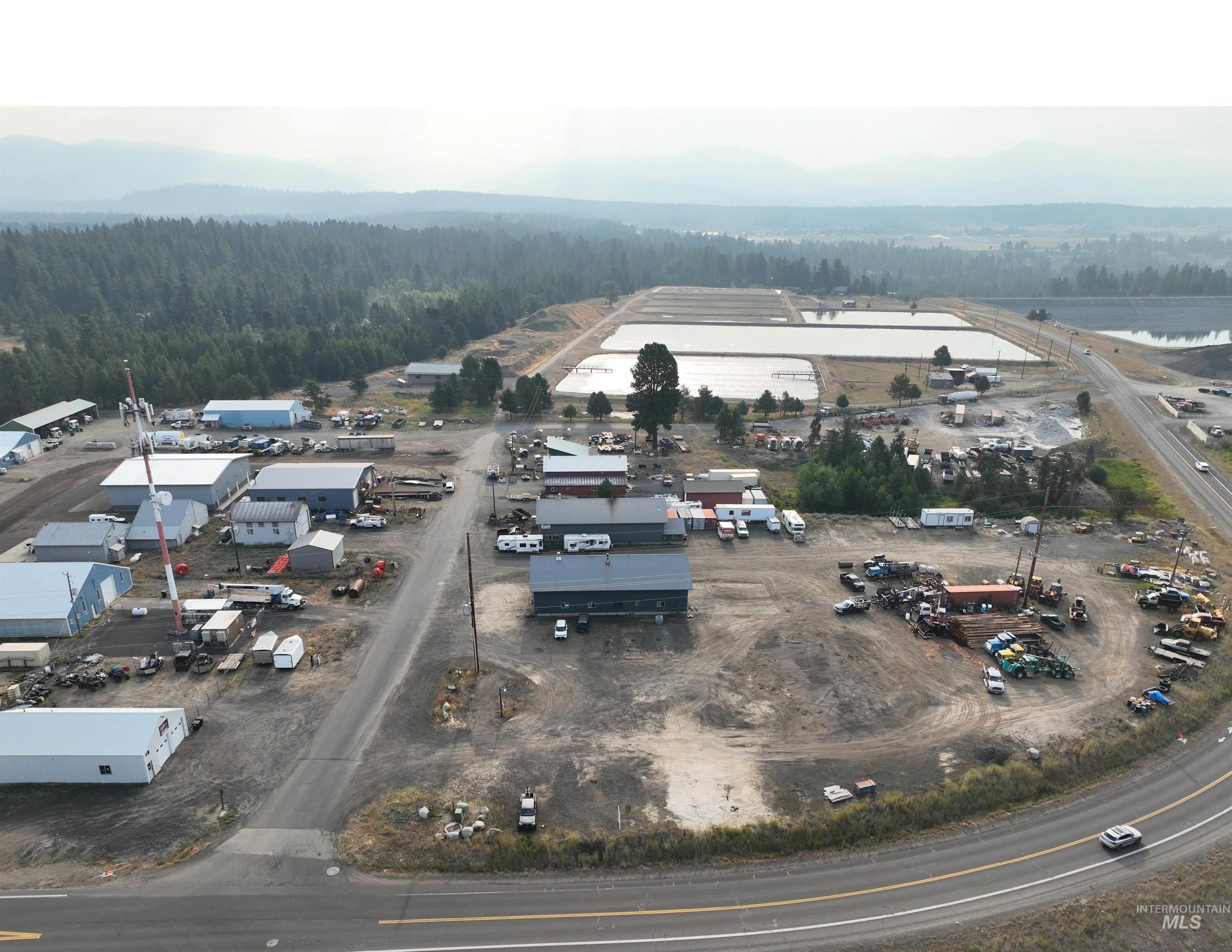 Drone / aerial view of a heavily wooded area and a mountain backdrop
