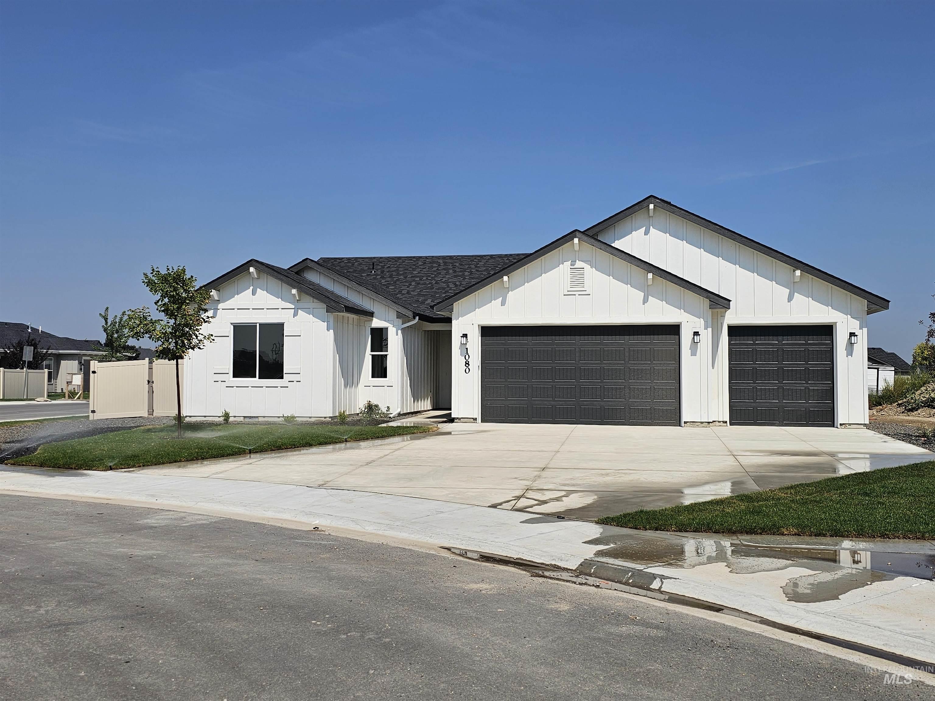 Modern farmhouse style home featuring driveway, a garage, board and batten siding, and a shingled roof