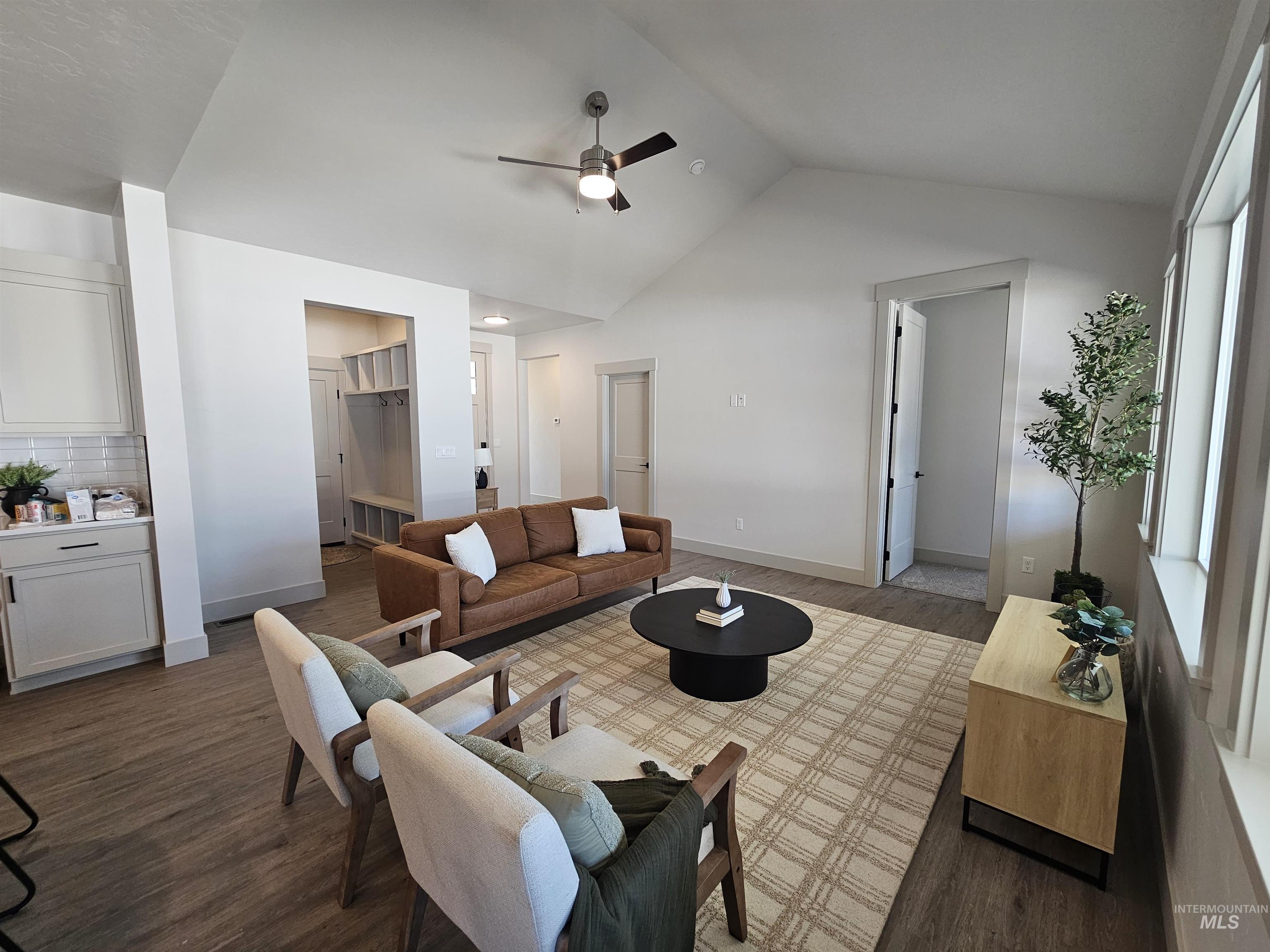 Living area featuring wood finished floors, ceiling fan, and high vaulted ceiling