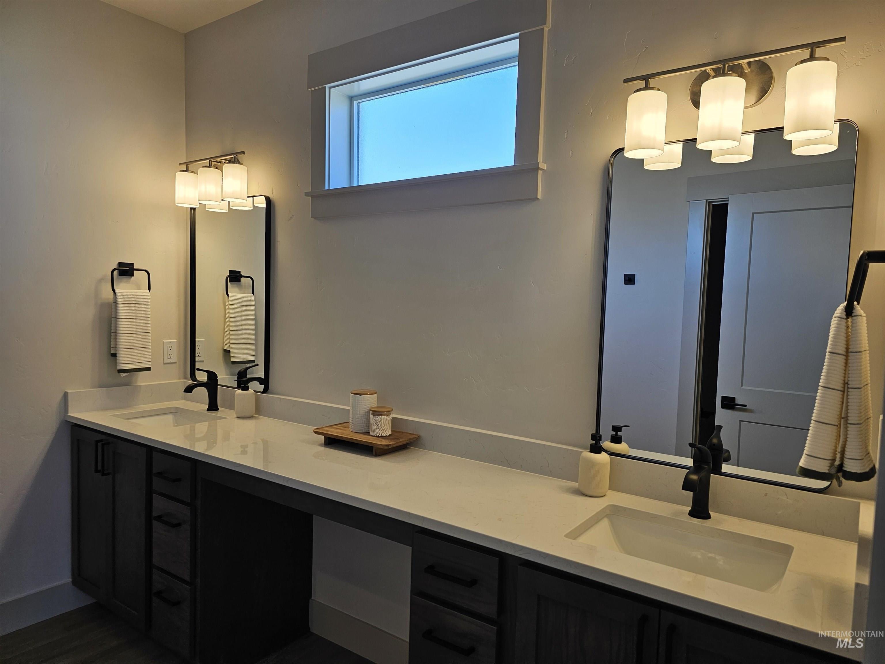 Full bathroom featuring double vanity and dark wood-style flooring