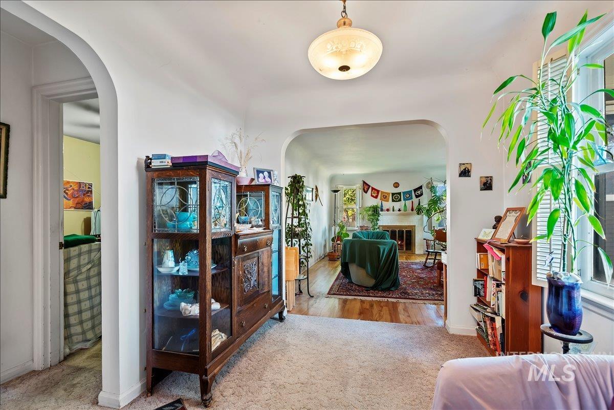 Carpeted entrance foyer with arched walkways and wood finished floors