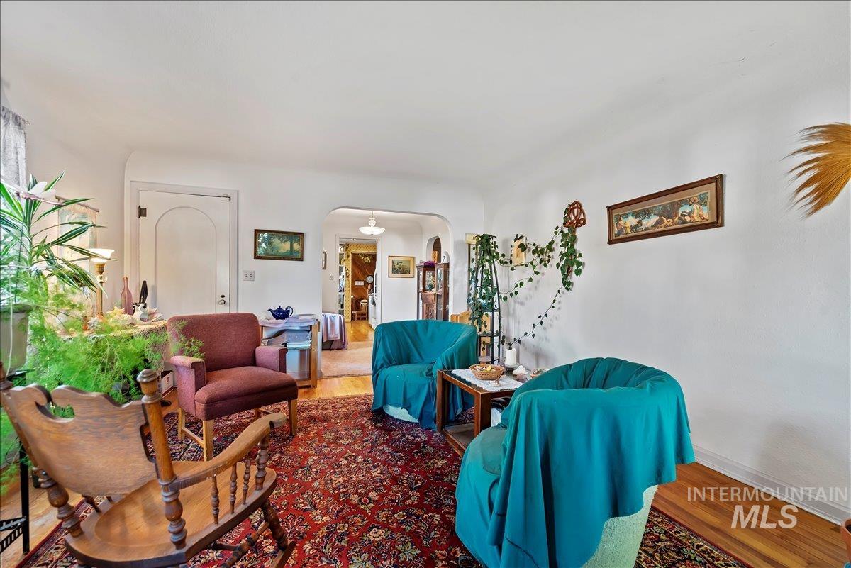 Living room featuring arched walkways and wood finished floors