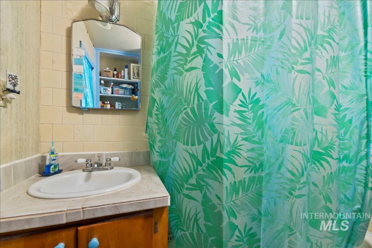 Full bath featuring a shower with shower curtain and vanity