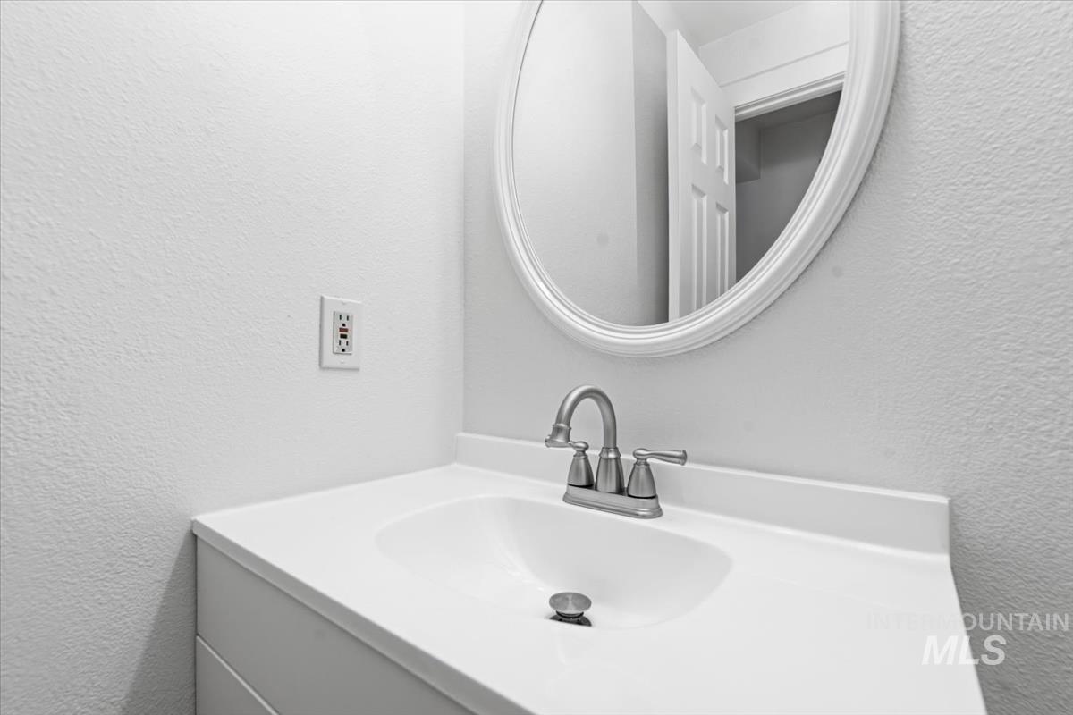 White vanity with an integrated sink and brushed nickel faucet