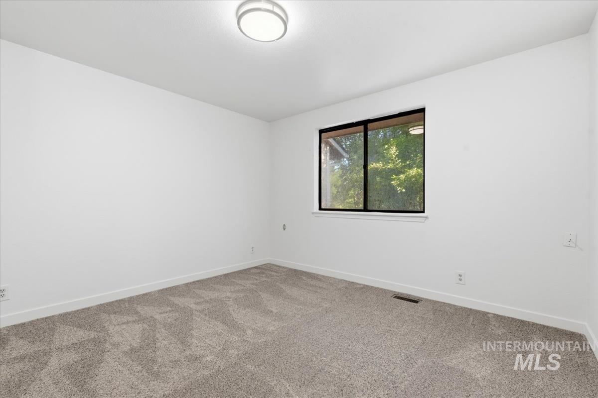 Room with neutral-toned carpeting and white walls