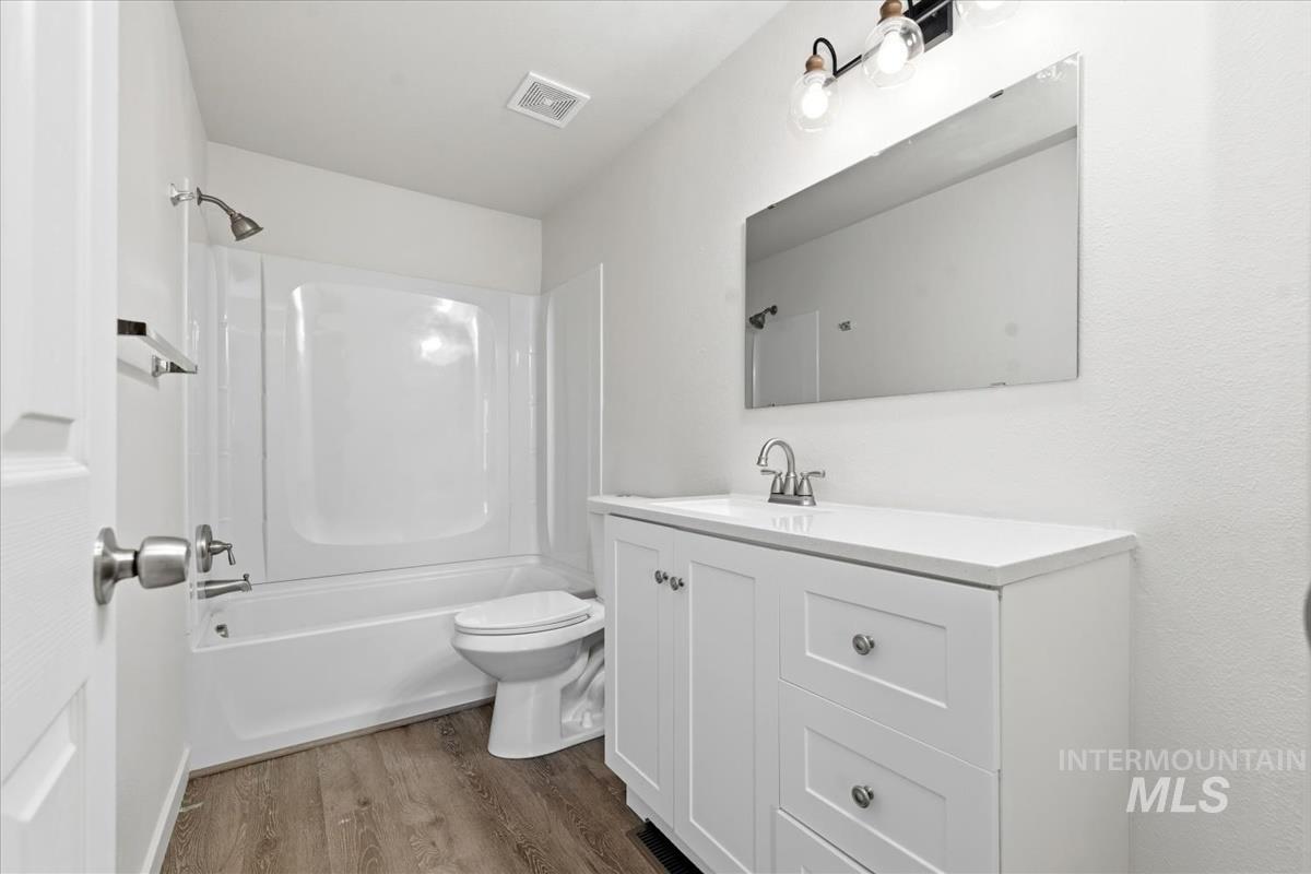 Bathroom featuring a white vanity with drawers, a single-basin sink, and a white countertop