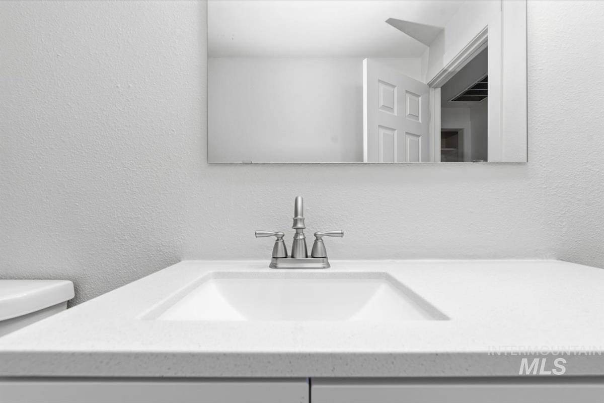 Integrated white sink with a brushed nickel faucet set on a light-toned countertop