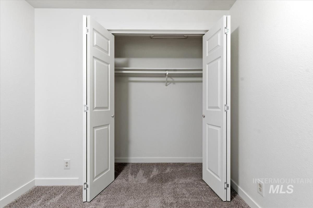 Double-door closet with panel doors, integrated shelving, and hanging rods