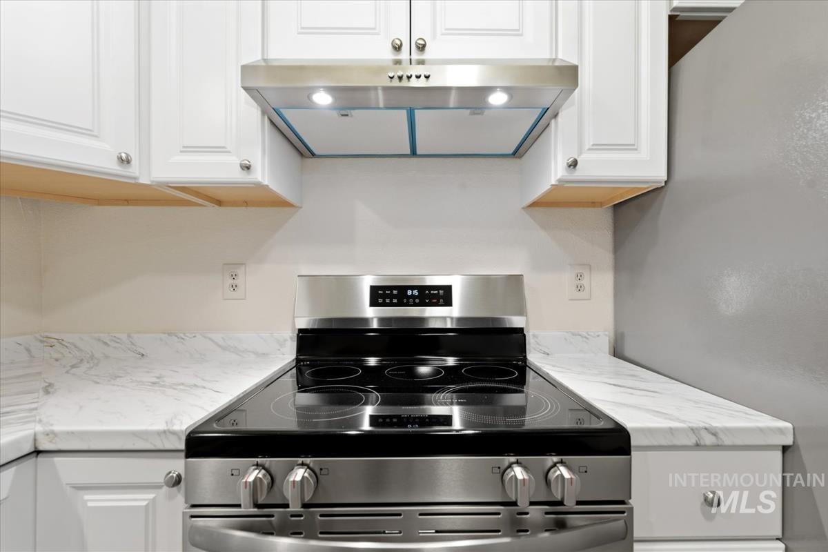Stainless steel electric range with a built-in oven and matching range hood