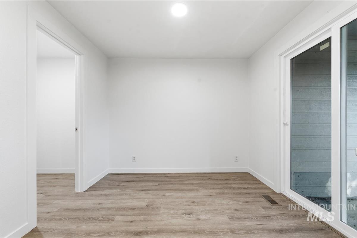 Bright interior space featuring wood-finish flooring and crisp white walls