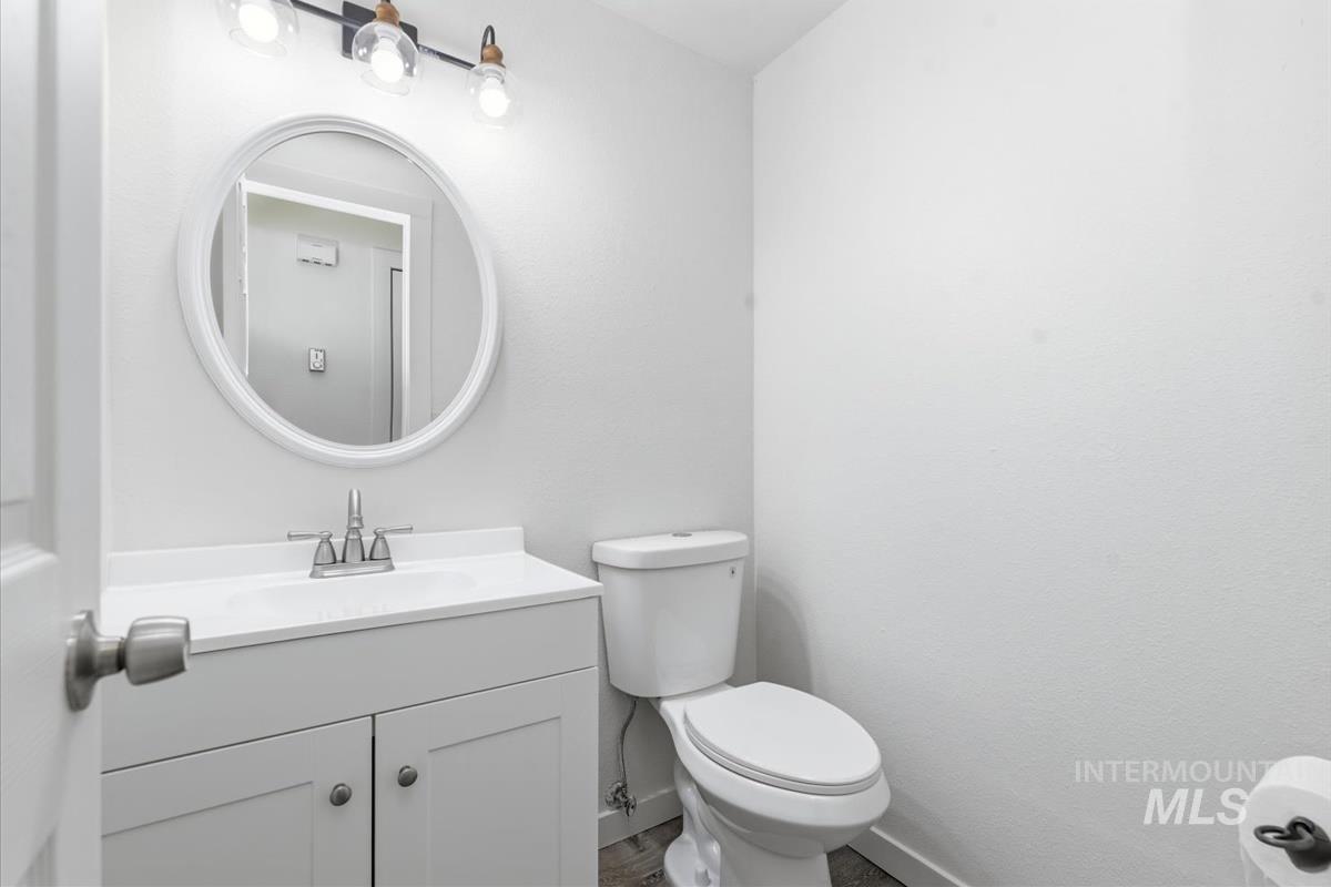 Vanity with white shaker cabinetry, an integrated sink, and a chrome faucet