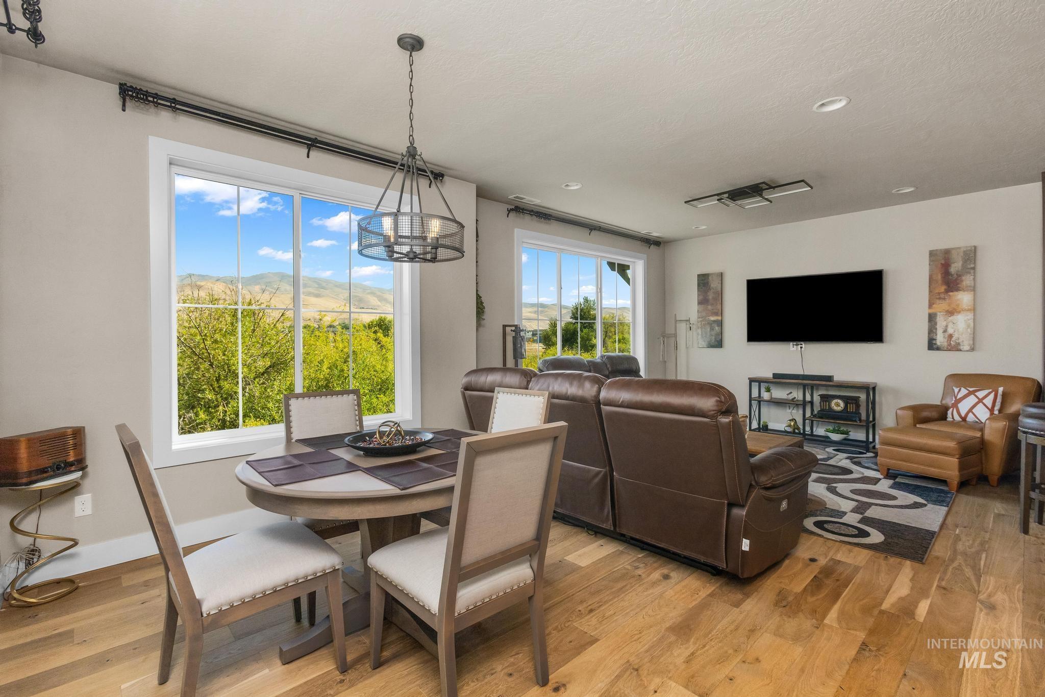 Dining room with light wood-style floors, a chandelier, and recessed lighting