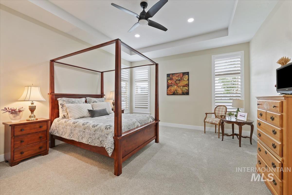 Primary suite with recessed lighting, and a tray ceiling
