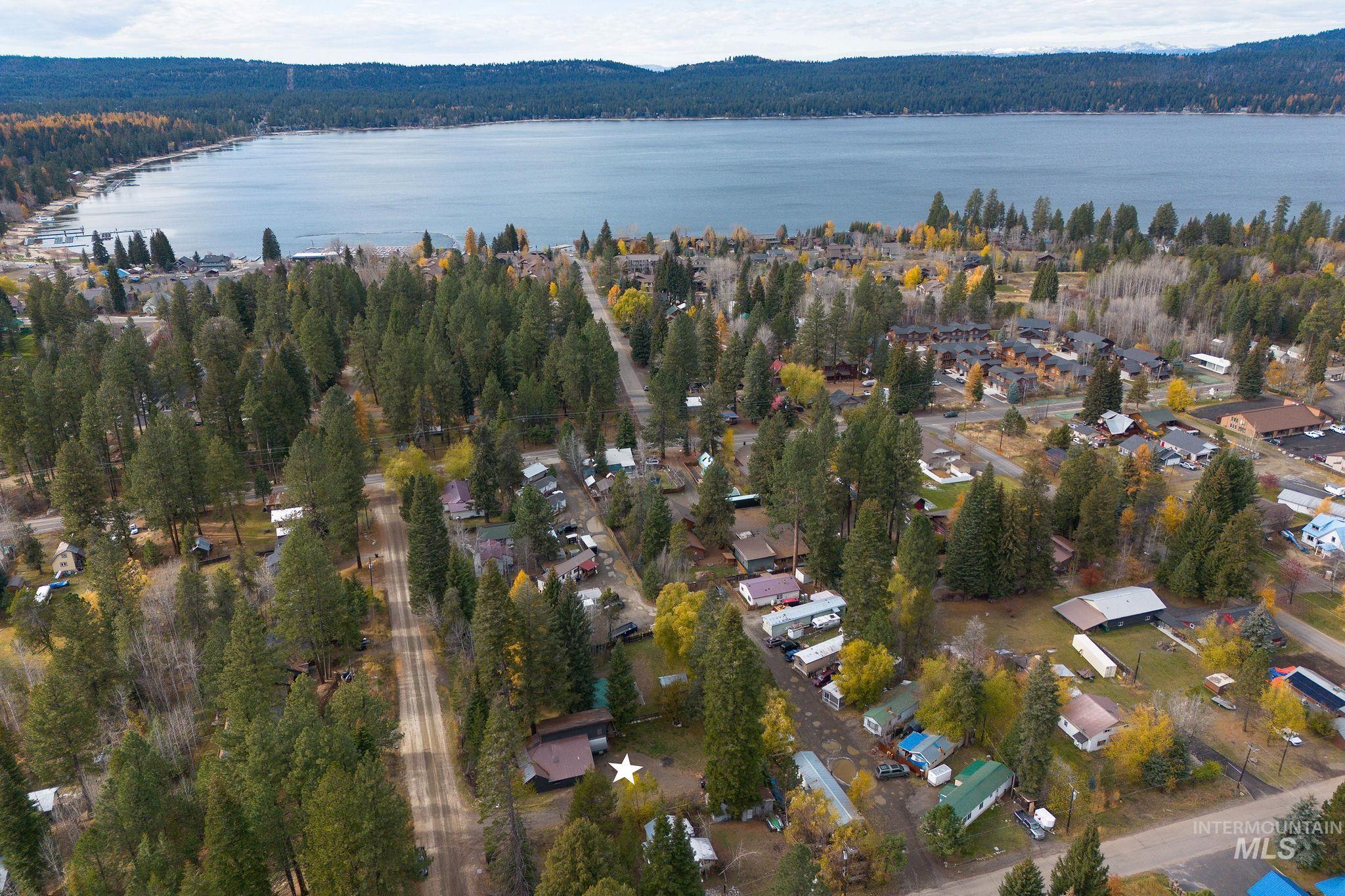 Aerial overview of property's location with a forest and a nearby body of water