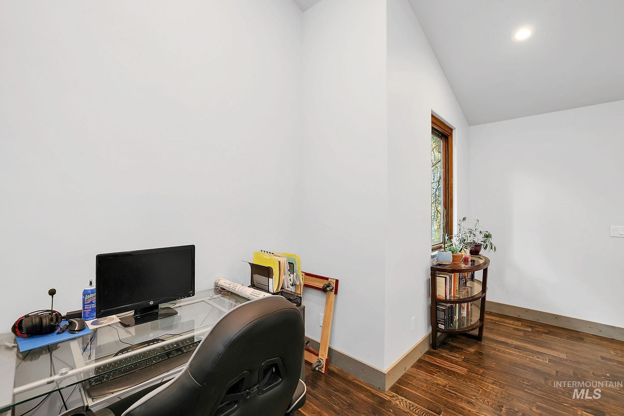 Office area with dark wood-style flooring, lofted ceiling, and recessed lighting