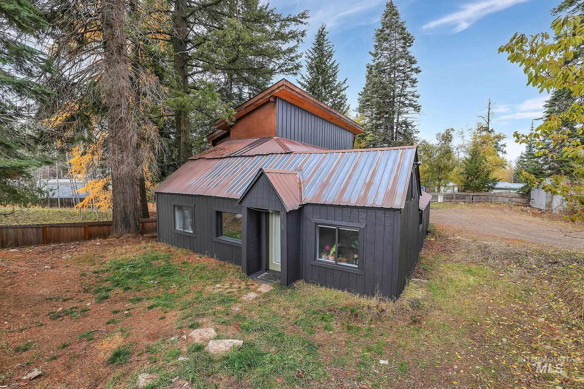 View of front facade featuring a metal roof and an outbuilding