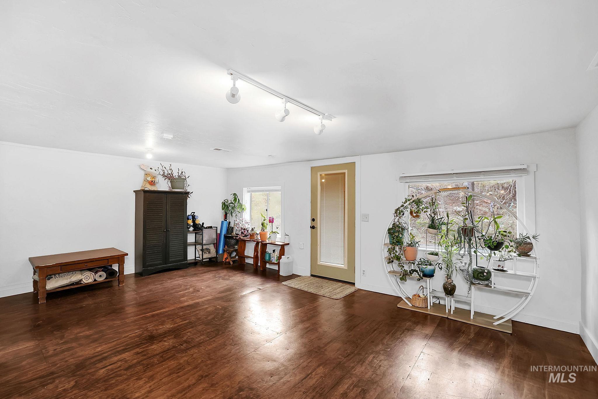 Living area featuring rail lighting and dark wood finished floors