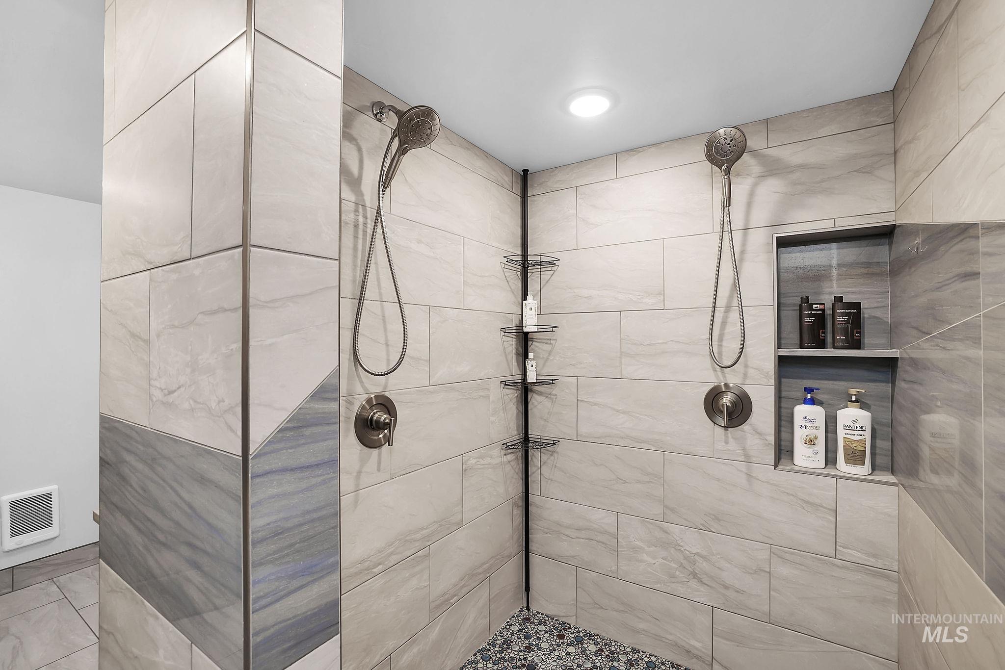 Full bath featuring tiled shower and heating unit