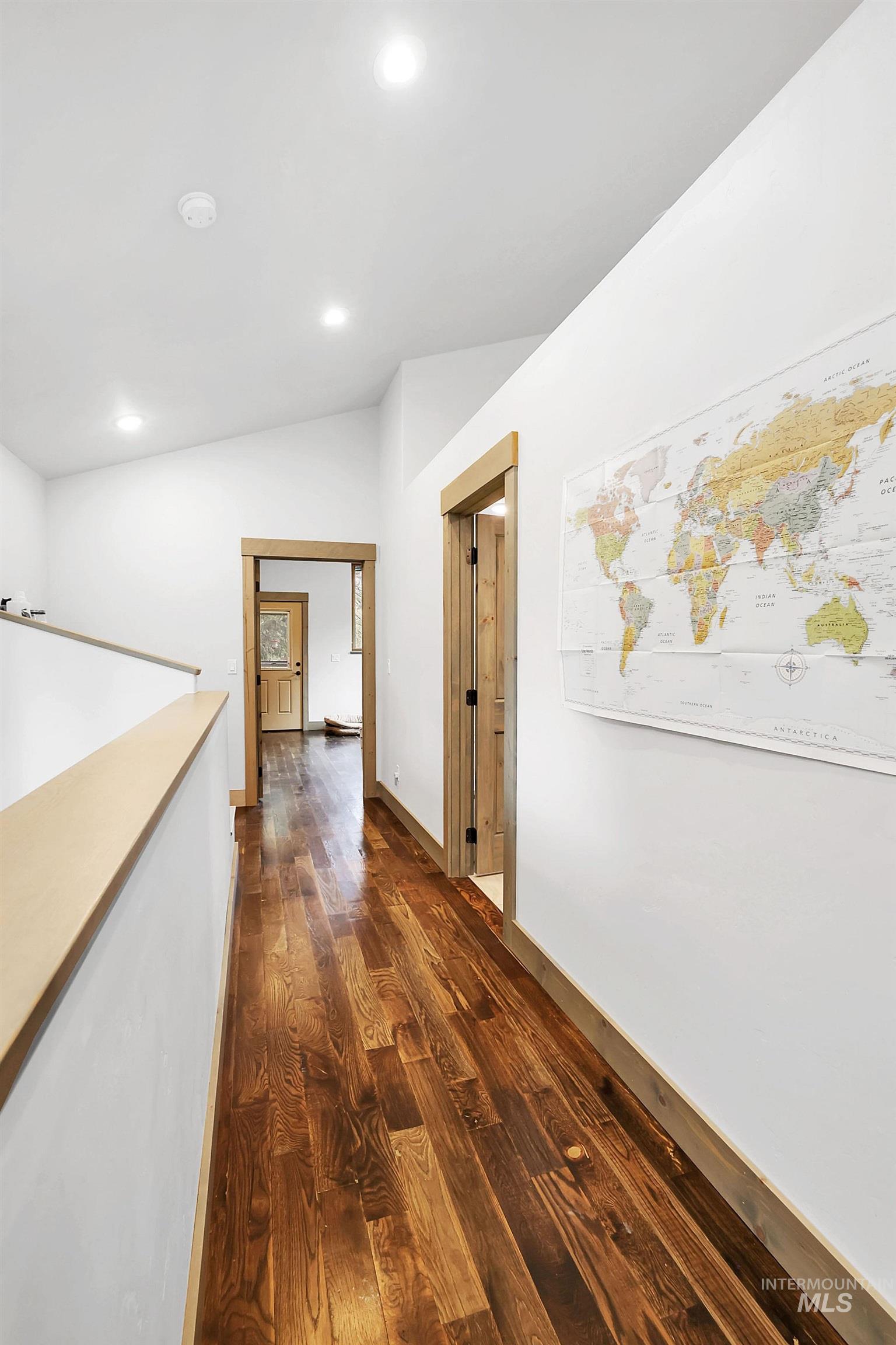 Hallway featuring dark wood-type flooring, vaulted ceiling, and recessed lighting