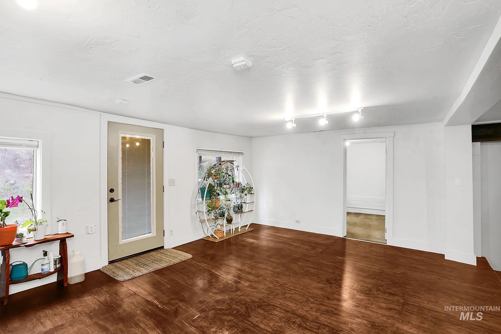 Unfurnished room featuring dark wood-style floors, a textured ceiling, and a smoke detector