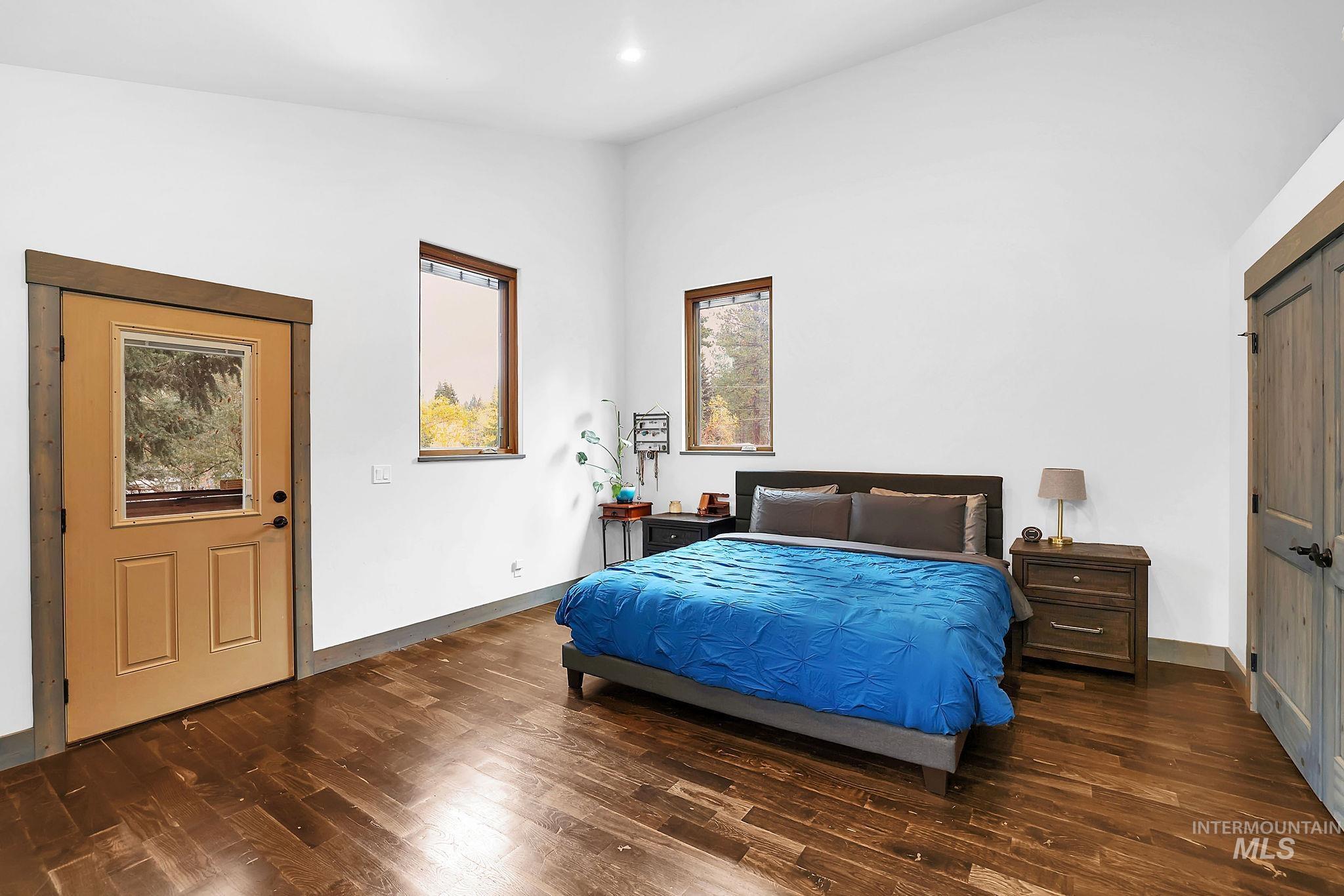 Bedroom with dark wood finished floors and baseboards