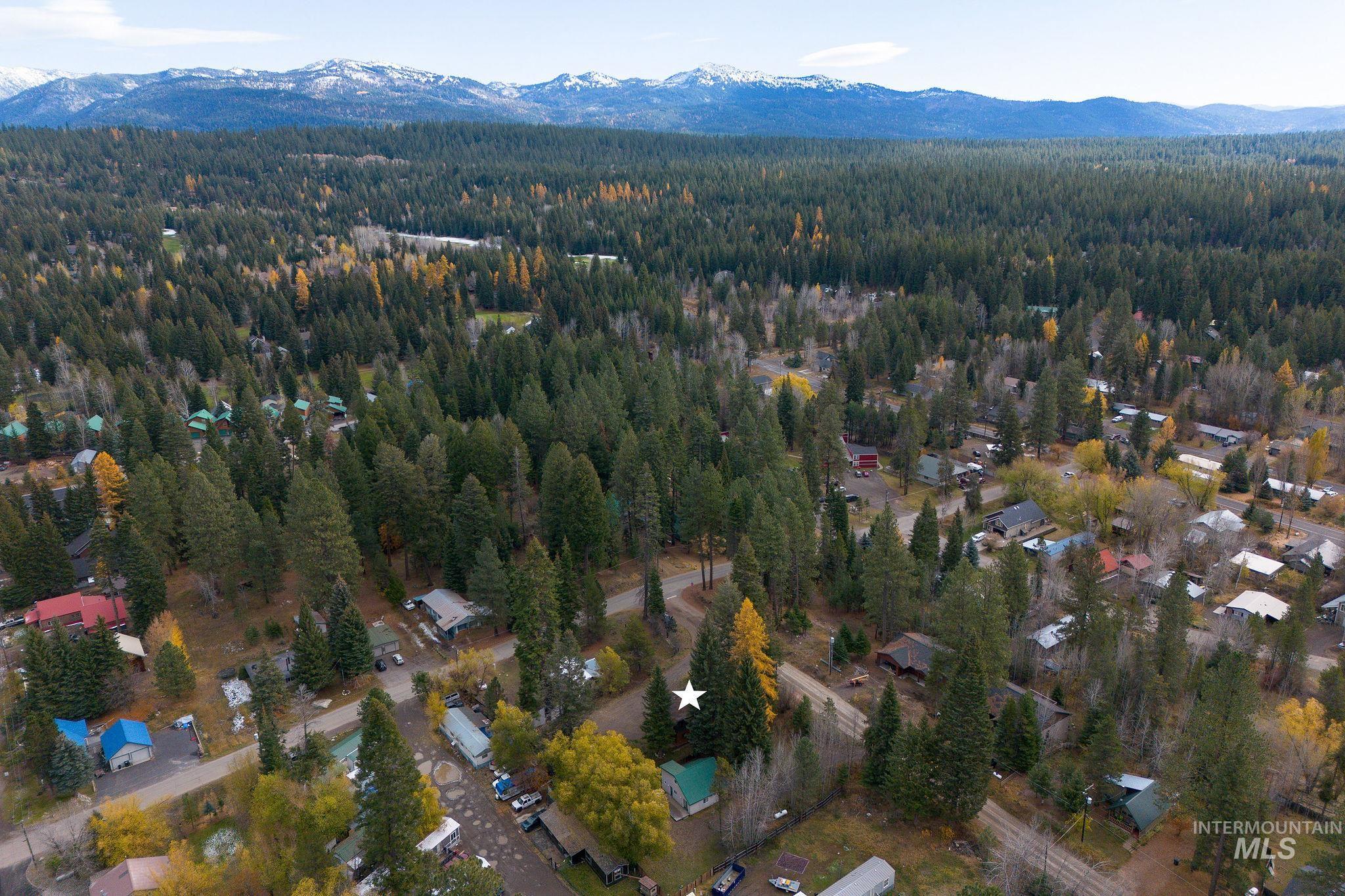 Aerial view of property and surrounding area with a mountain backdrop