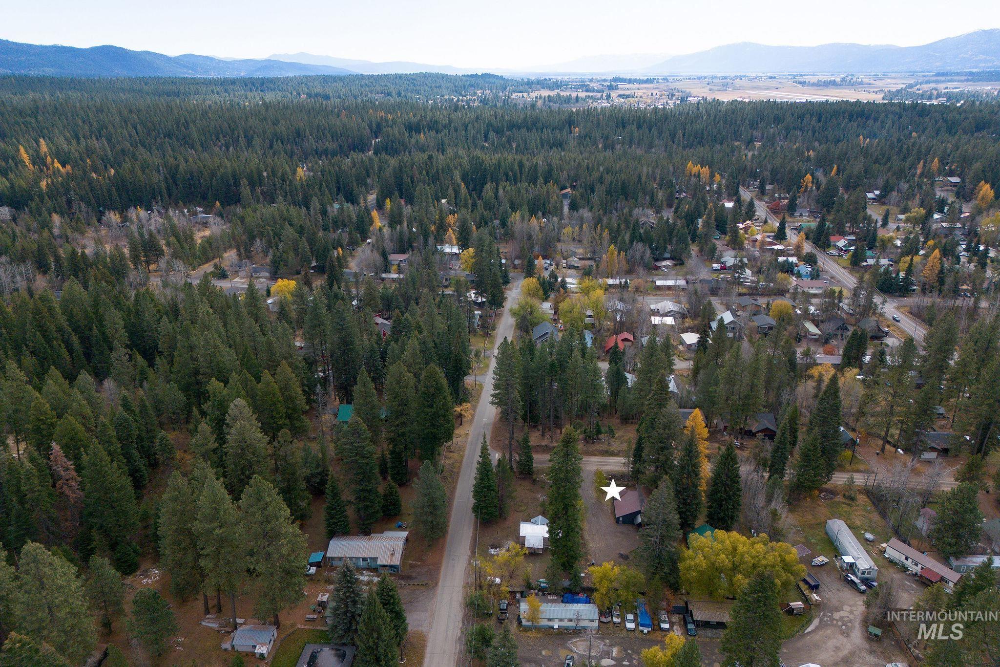 Aerial view of property's location with a mountainous background and a forest