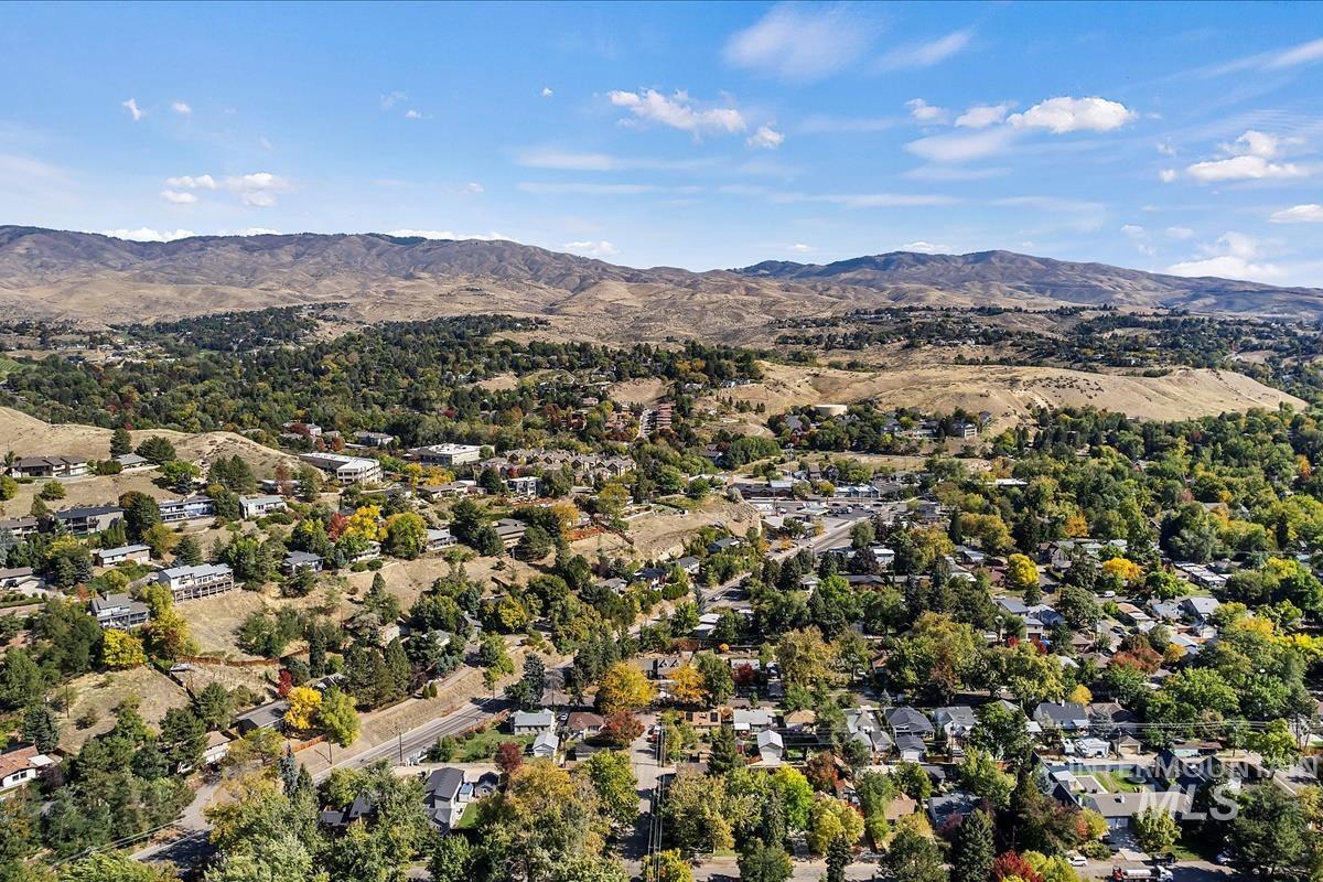 Aerial view of property and surrounding area with a mountain backdrop