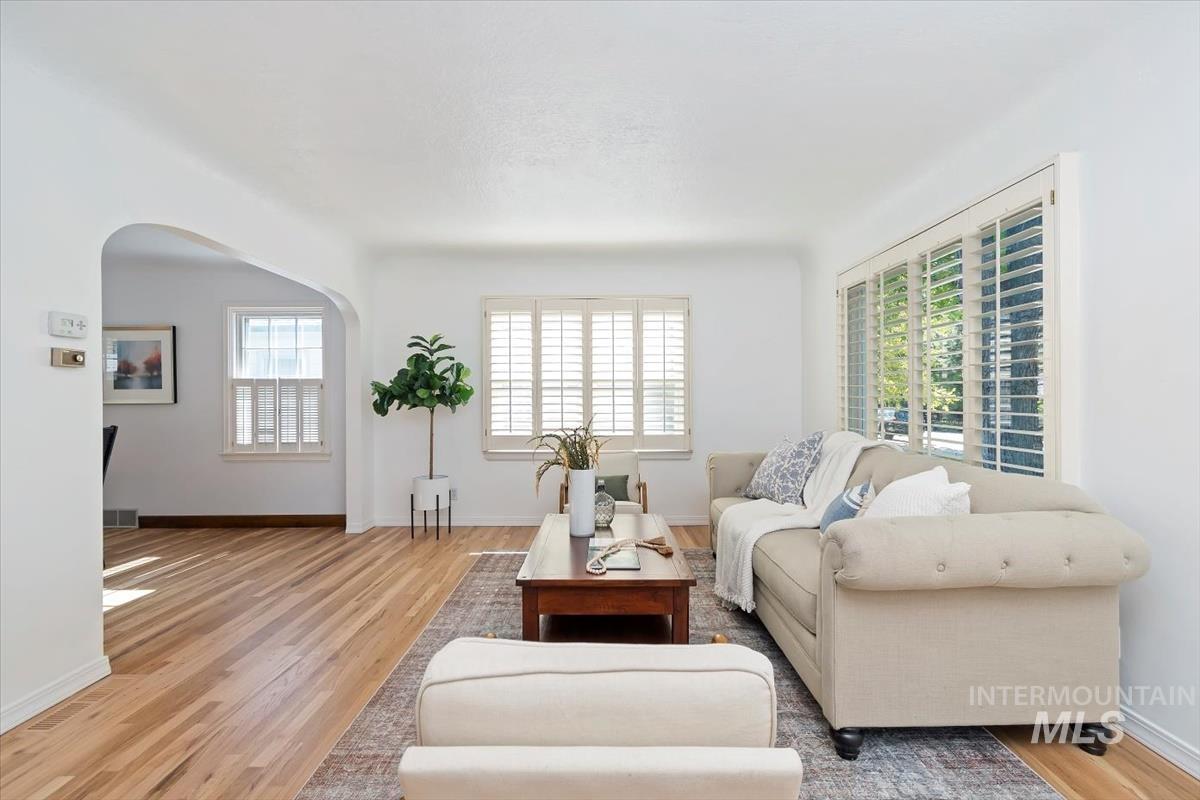 Living area featuring arched walkways and wood finished floors