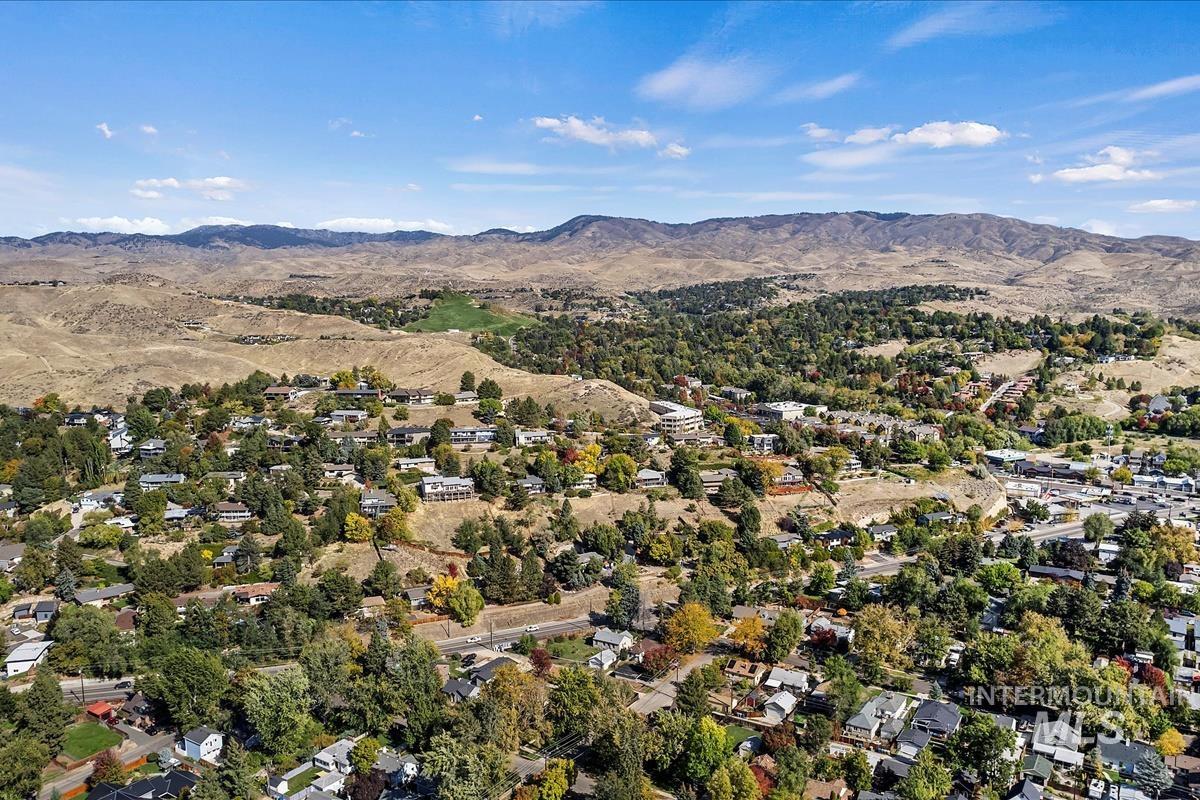 Aerial view of property and surrounding area with a mountain backdrop