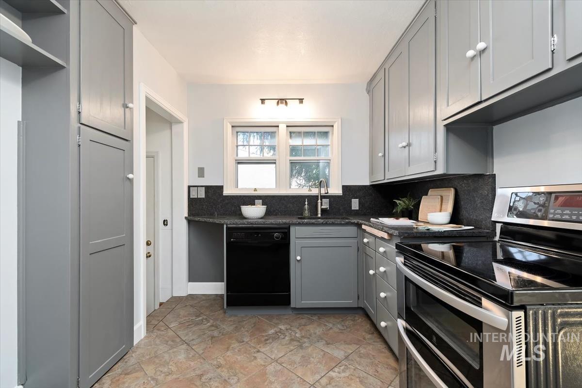 Kitchen with gray cabinetry, double oven range, tasteful backsplash, dishwasher, and open shelves