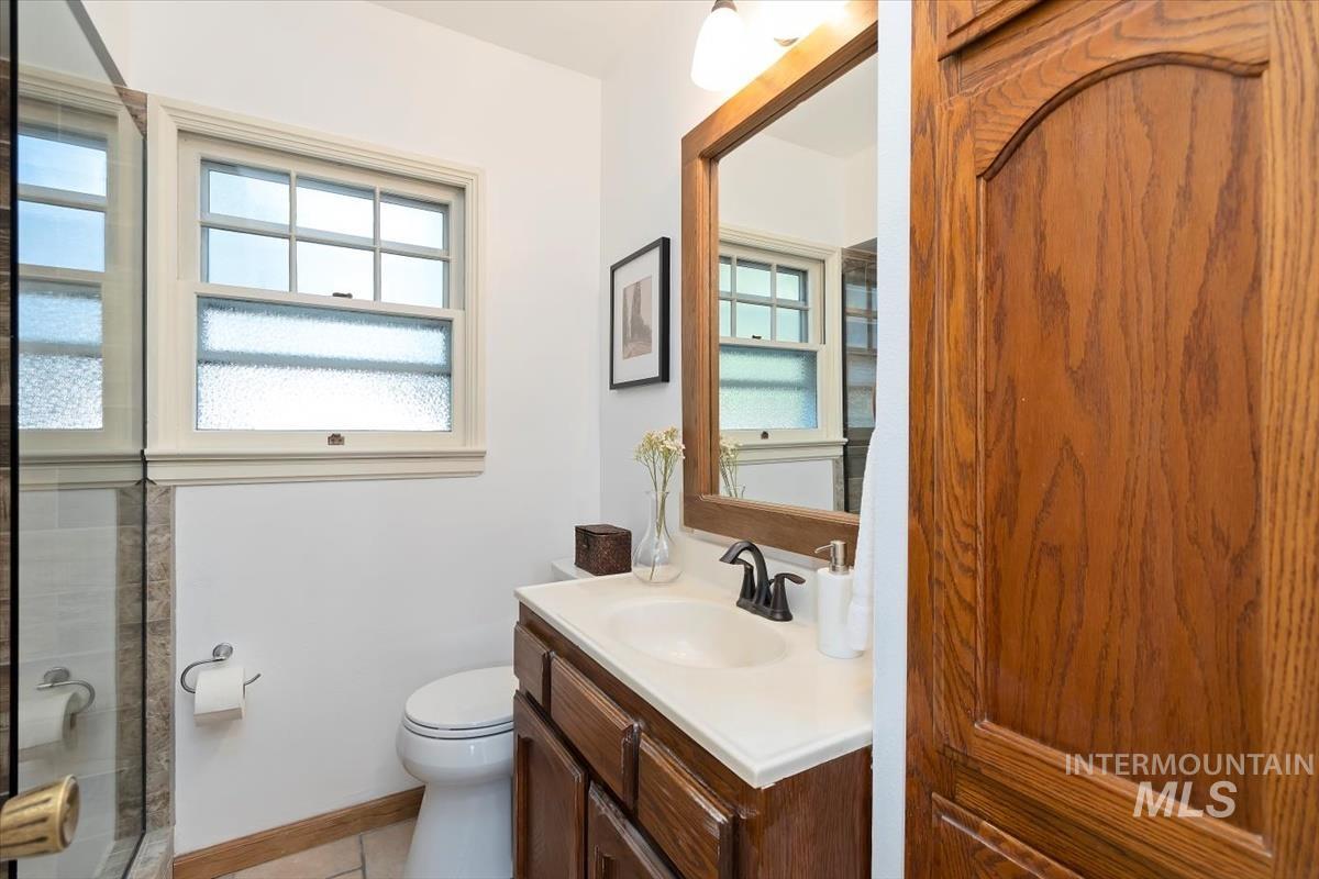 Full bathroom featuring vanity, plenty of natural light, a shower, and tile patterned floors