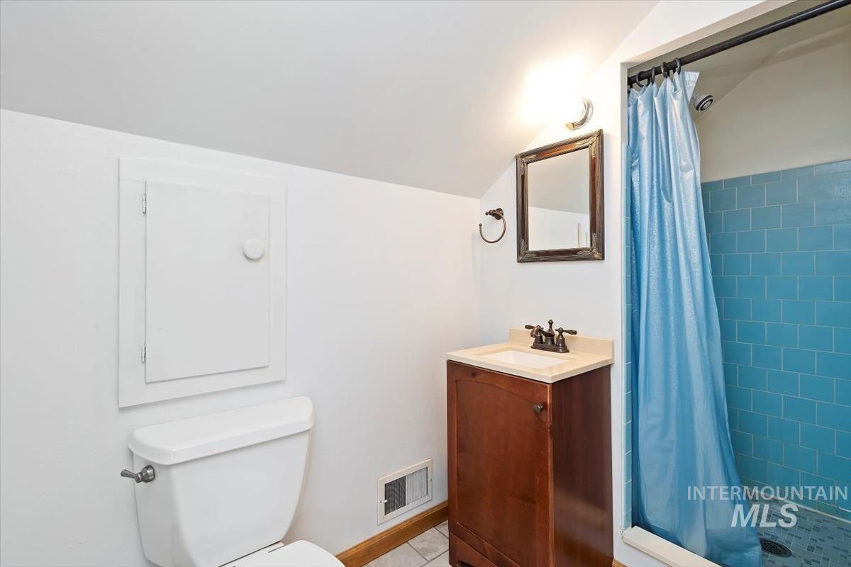 Full bath featuring vanity, a stall shower, and light tile patterned floors