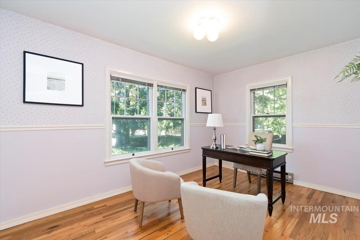 Office area featuring light wood finished floors, wainscoting, healthy amount of natural light, a baseboard radiator, and wallpapered walls