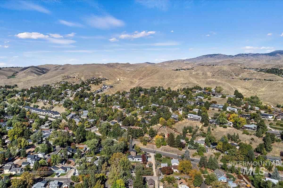 Aerial view of property and surrounding area featuring a mountain backdrop