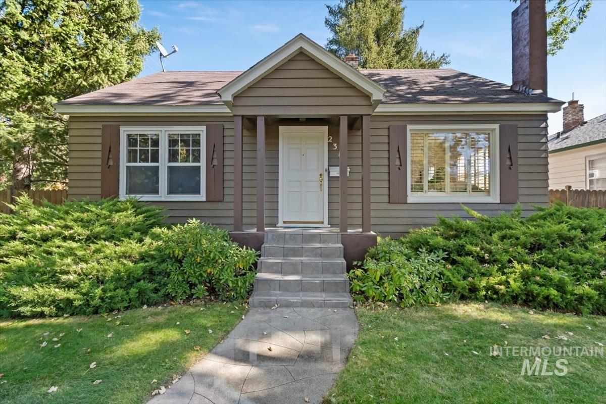 View of front facade with a chimney and roof with shingles