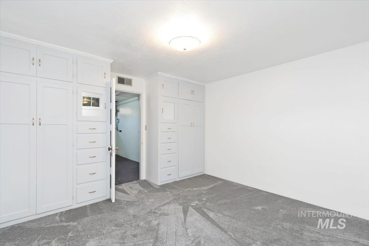 Unfurnished bedroom with dark carpet and a closet
