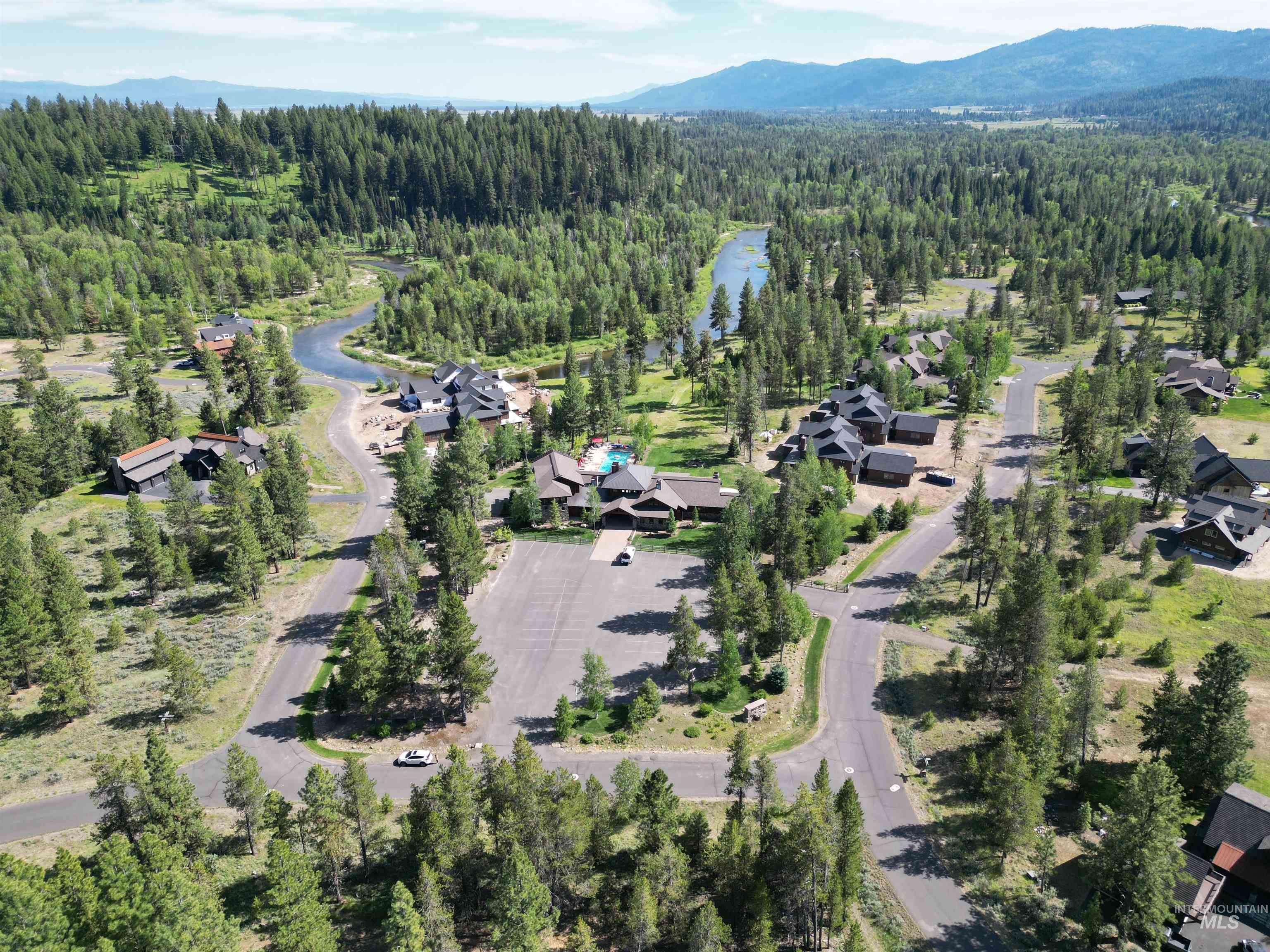 Aerial overview of property's location featuring a forest and a water and mountain view