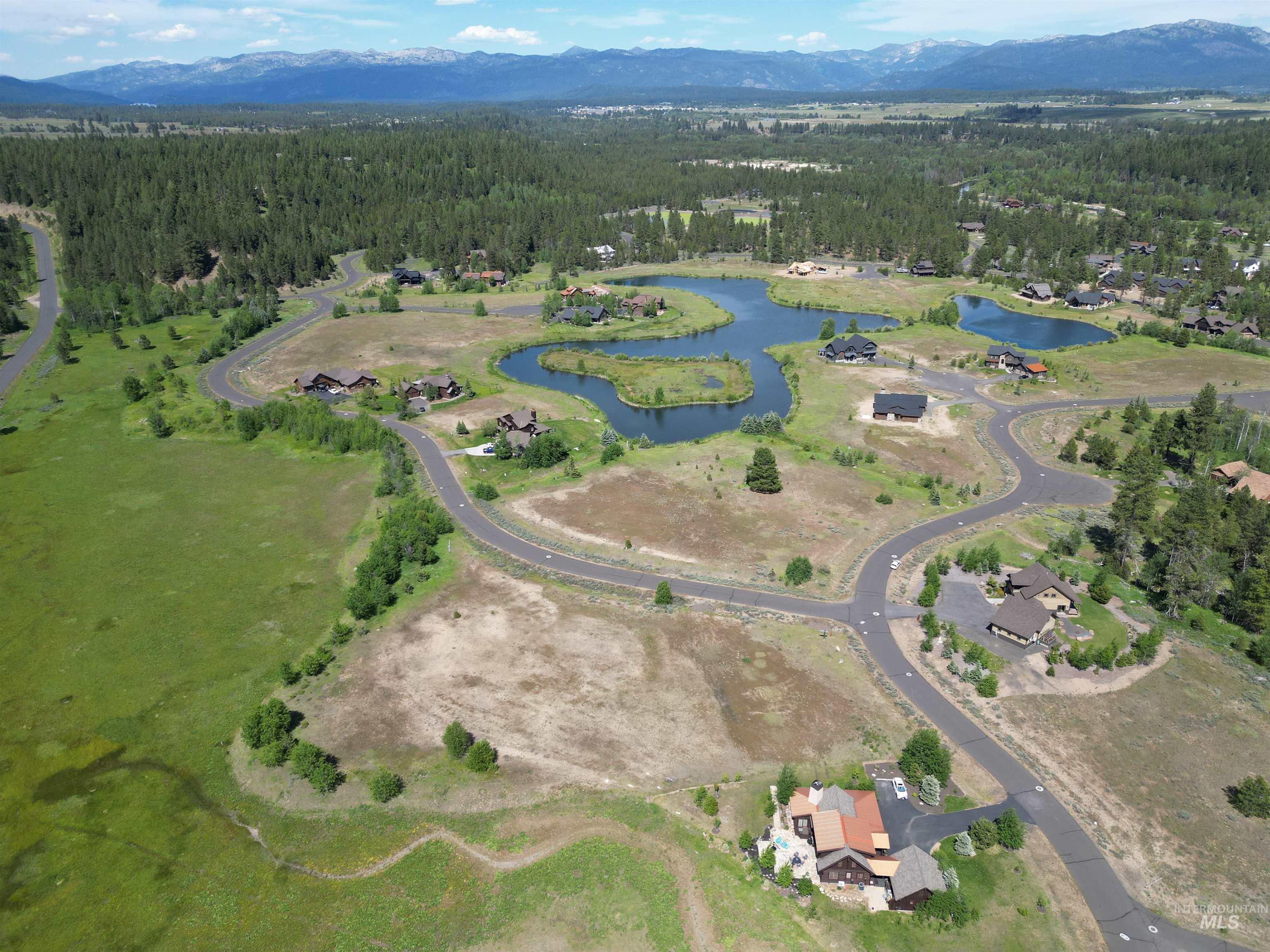 Aerial view of property's location with a forest and a water and mountain view