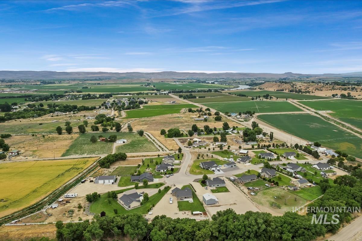 Aerial view of property and surrounding area featuring rural landscape and a mountainous background