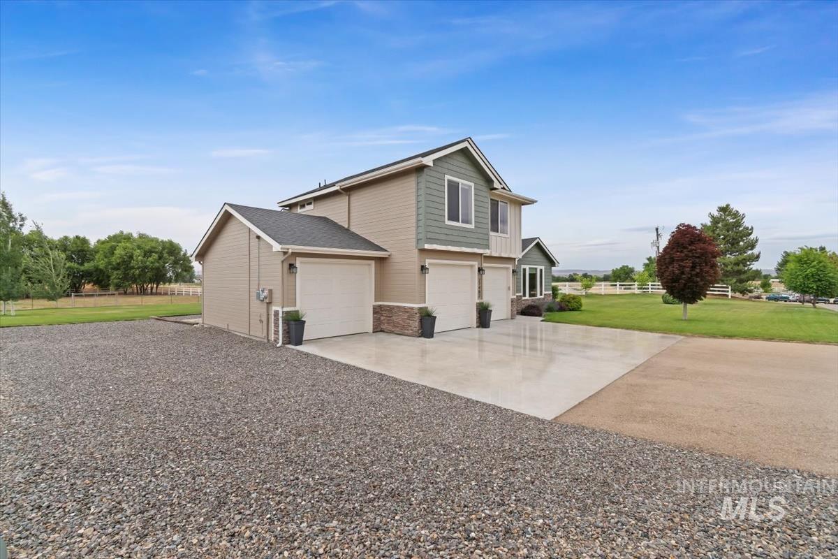 View of property exterior with concrete driveway and an attached garage