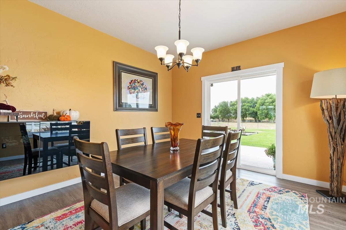 Dining space with wood finished floors and a chandelier