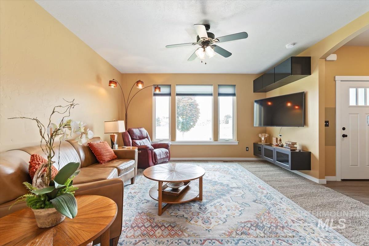 Living area with arched walkways and a ceiling fan