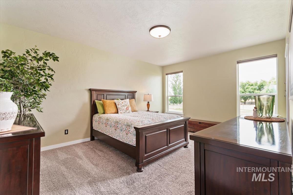 Bedroom featuring light carpet and baseboards