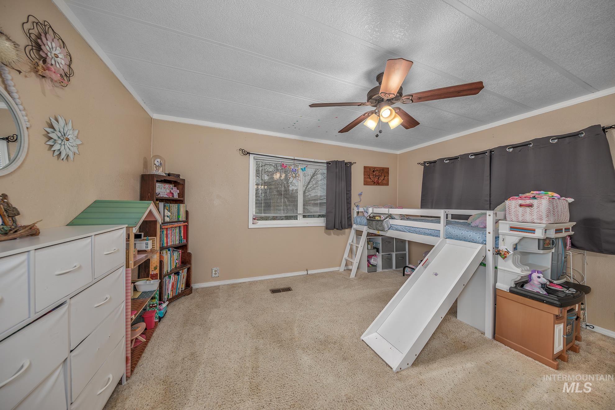Bedroom with crown molding, a ceiling fan, and light carpet
