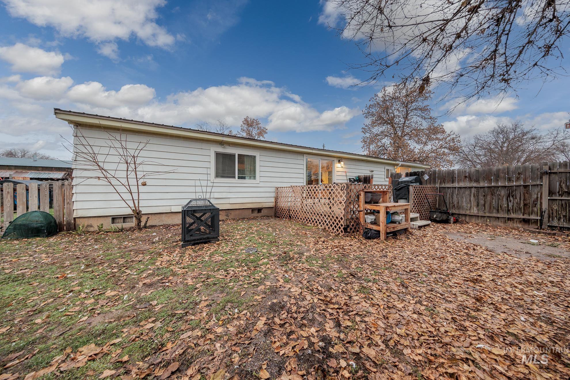 Rear view of house with crawl space, a wooden deck, and an outdoor fire pit