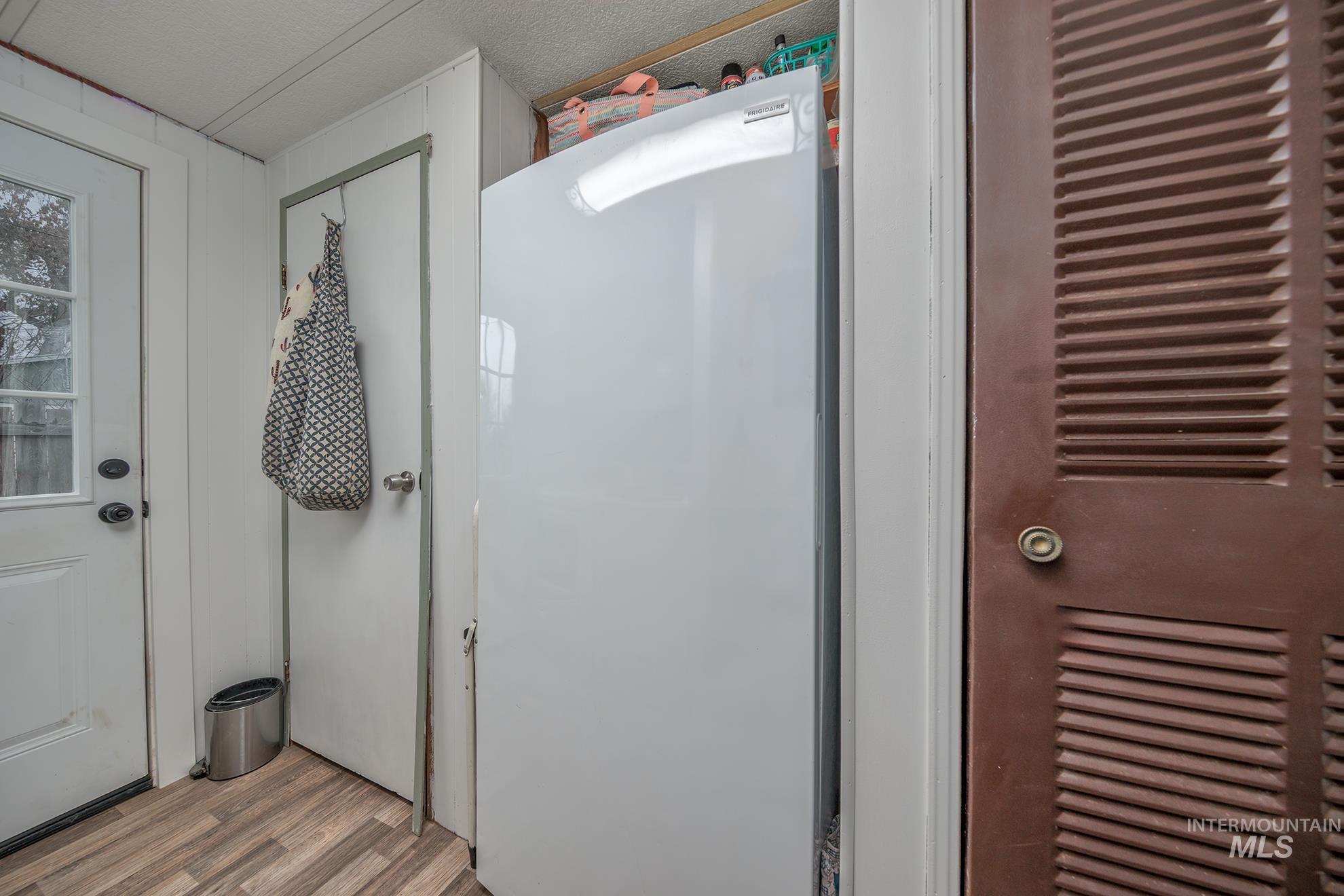 Detailed view of freestanding refrigerator and wood finished floors