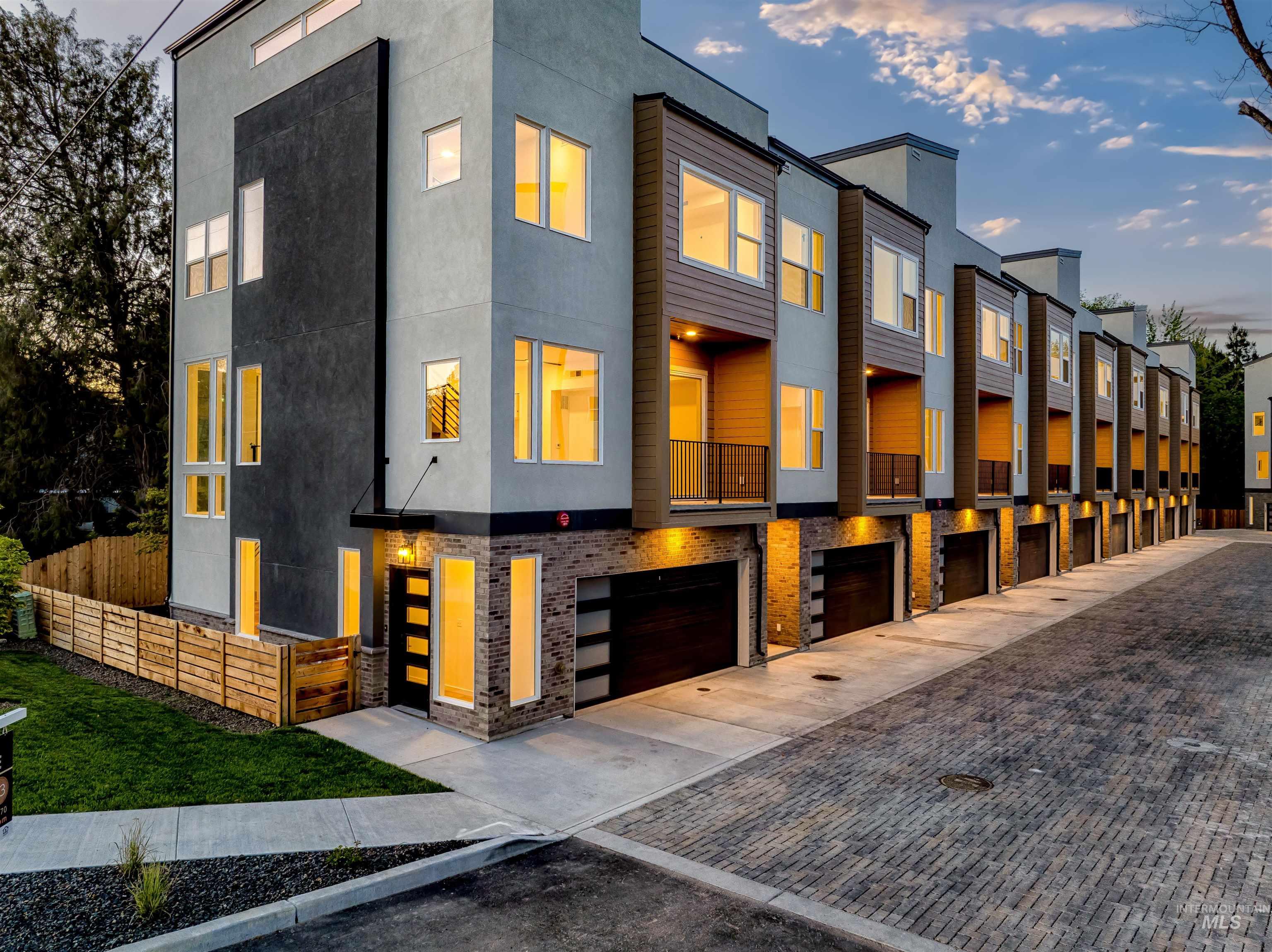 View of front facade with stucco siding, driveway, a residential view, and an attached garage