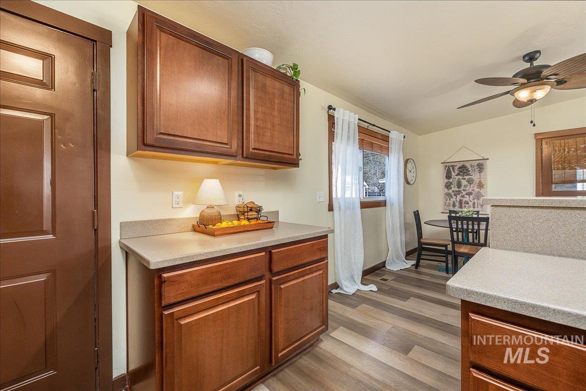 Kitchen featuring a ceiling fan, wood finish cabinets, and dark wood-type flooring
